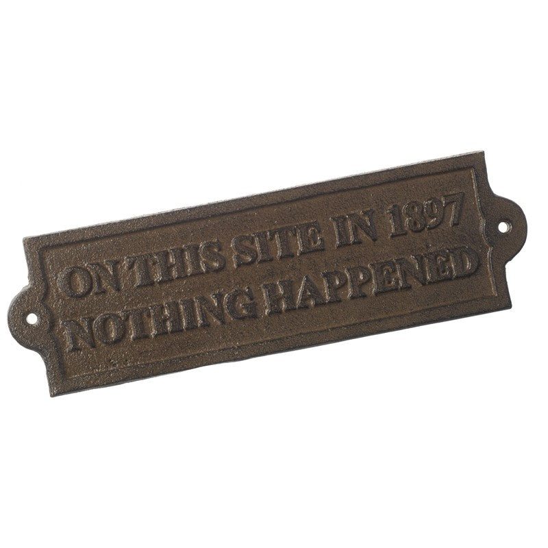 Bronze plaque with text 'On this site in 1897 nothing happened' on a white background