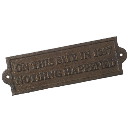 Bronze plaque with text 'On this site in 1897 nothing happened' on a white background