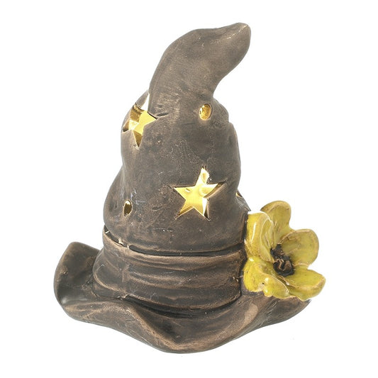 A wizard hat-shaped candle holder or decor piece in dark brown with gold star cutouts and a yellow flower accent, shown on a plain white background.
