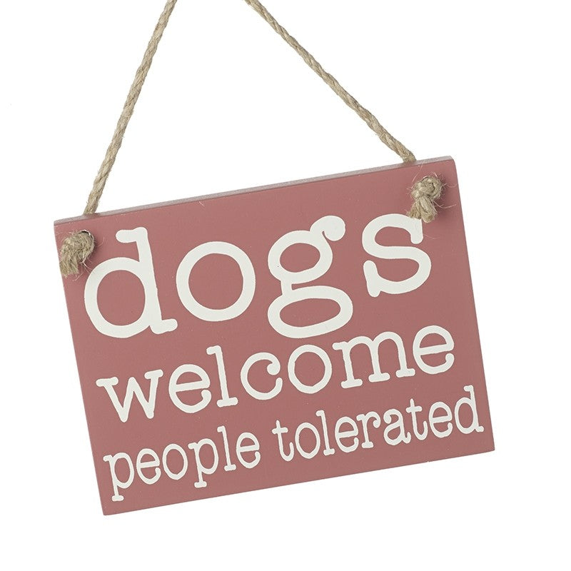 Pink sign with 'dogs welcome, people tolerated' text on a white background