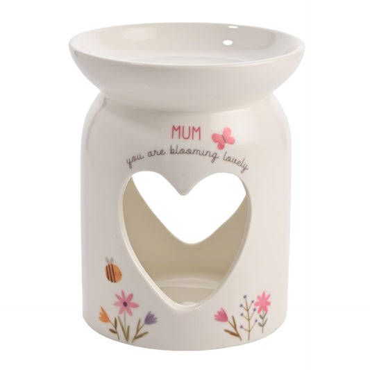 Ceramic warmer with heart cutout and floral designs on a white background