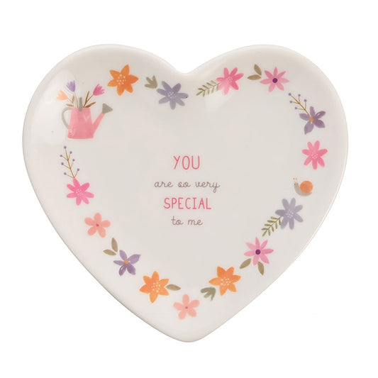 Heart-shaped ceramic plate with floral designs and text on a white background