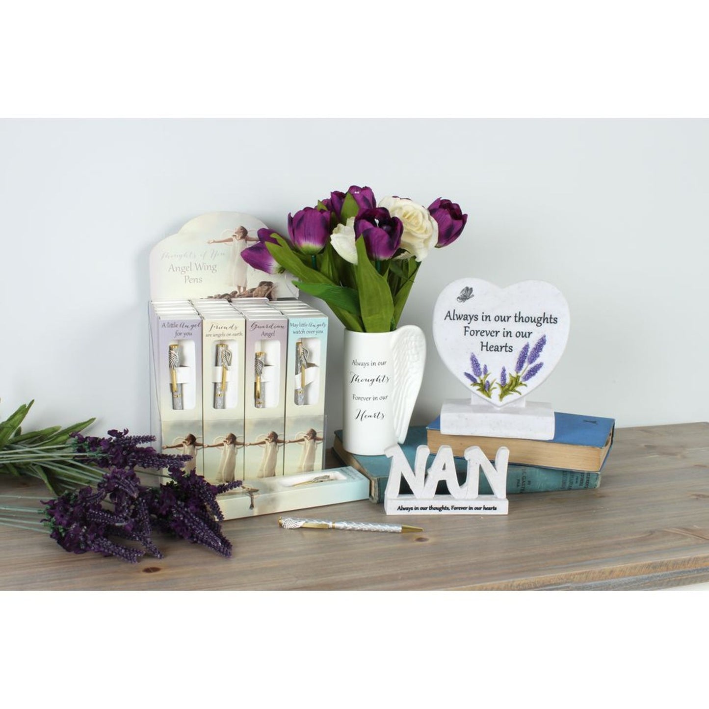 Memorial items including candles, flowers, and a 'Nan' plaque on a wooden surface.