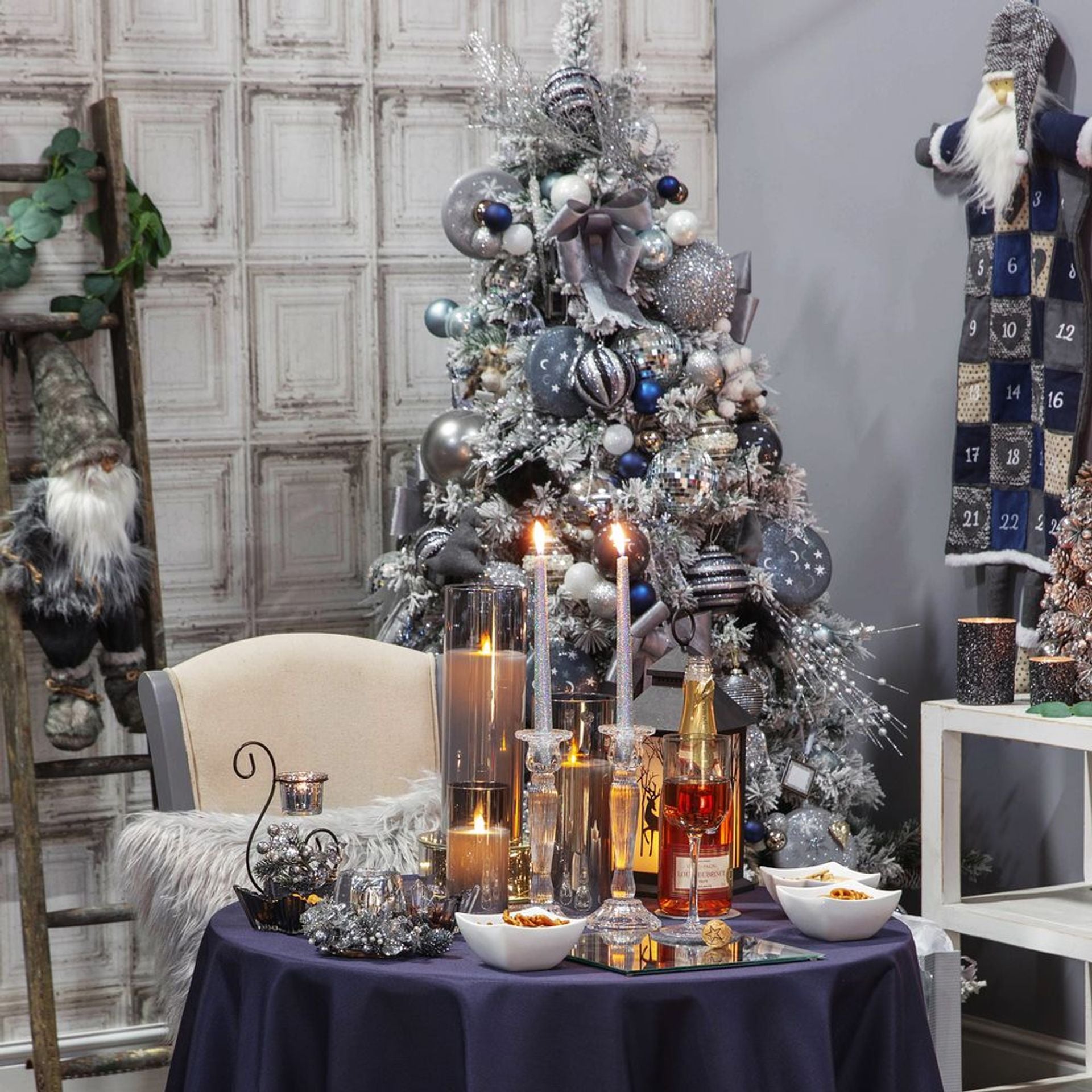 Decorated Christmas tree with ornaments and a table set for a festive meal.