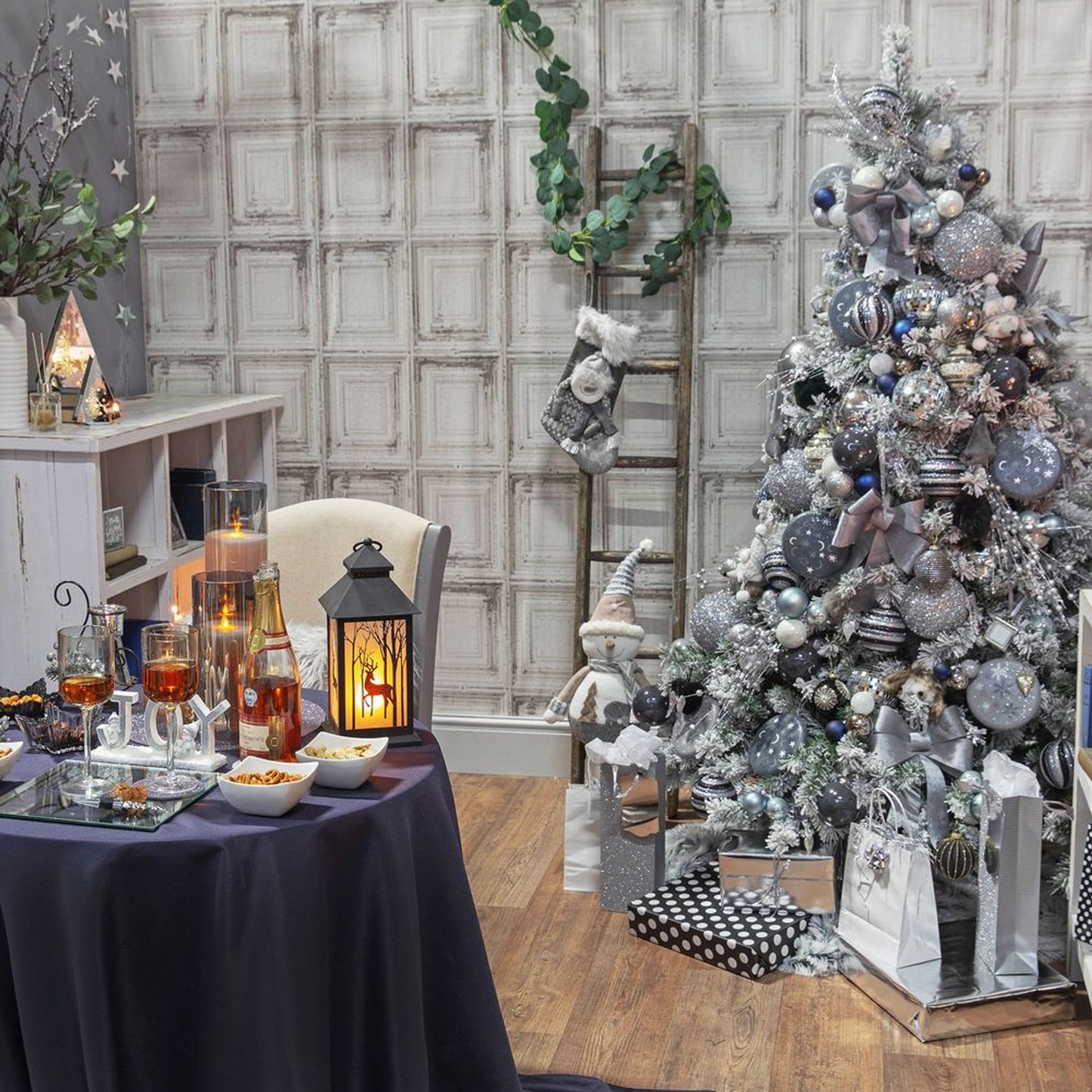 Decorated Christmas tree with a table set for a festive gathering in a room with a checkered wall.