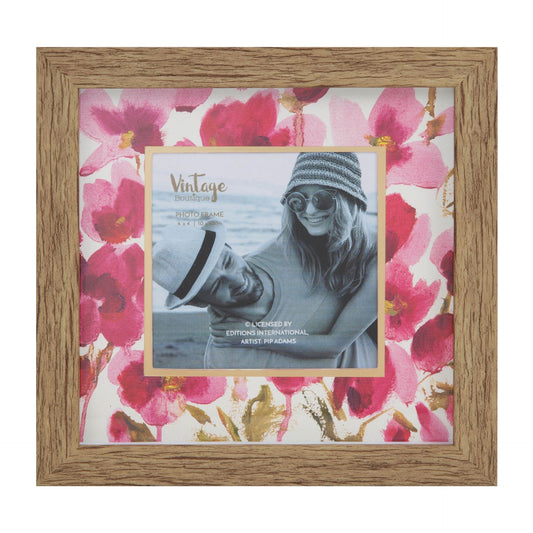 Wooden photo frame with floral design and a smaller photo of a person wearing sunglasses and a hat.