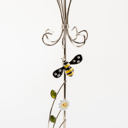 Decorative metal stand with a bee and flower design on a white background