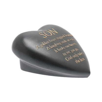 Heart-shaped black stone with engraved text on a white background