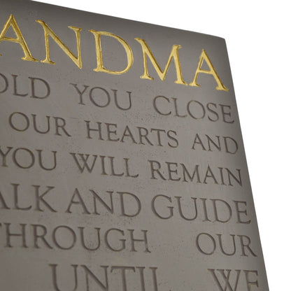 Decorative plaque with gold text on a gray background
