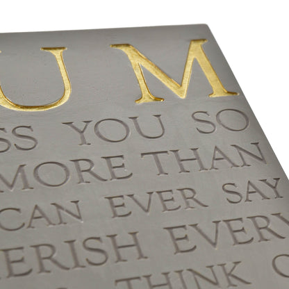 Embossed text on a metallic surface with gold and silver colors.