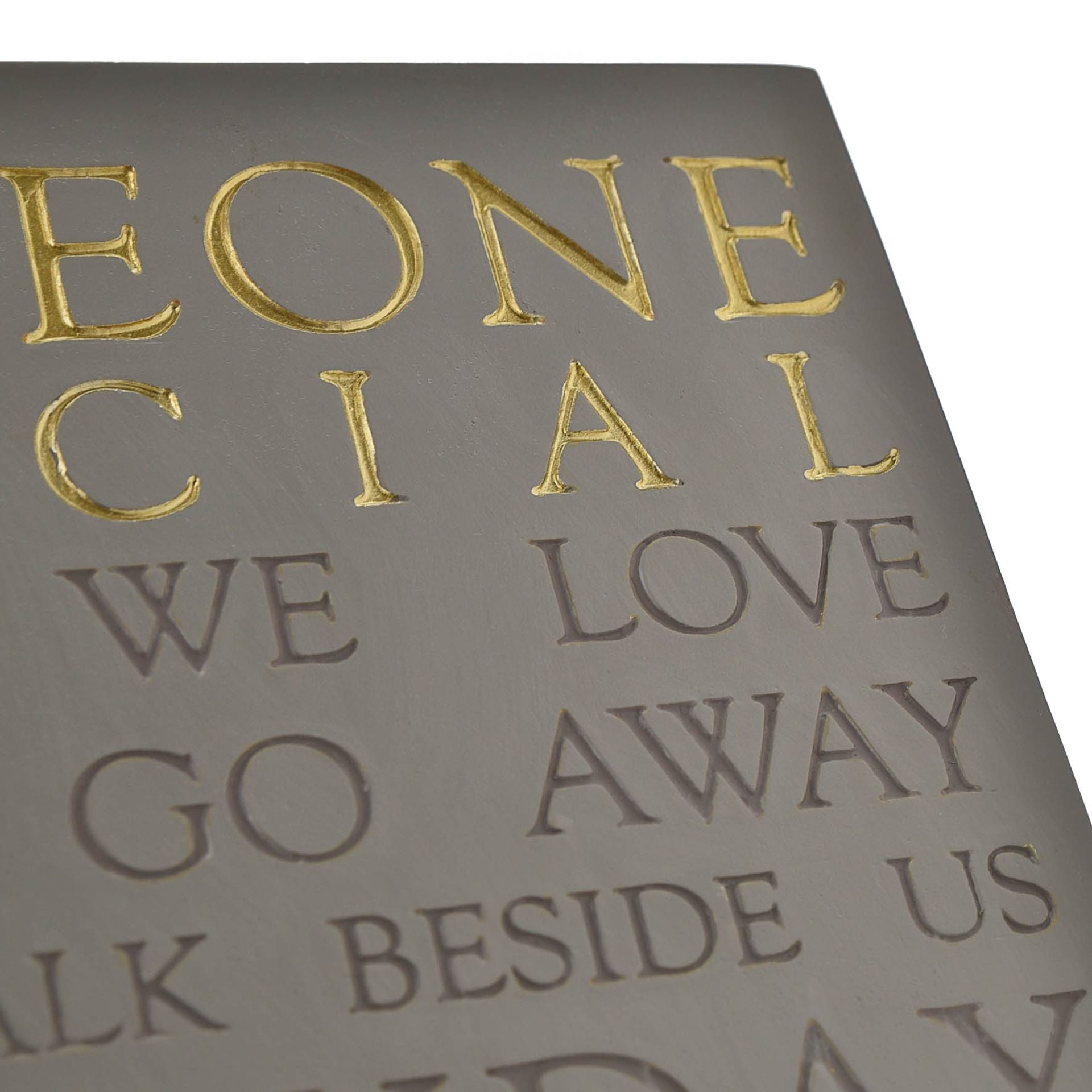 Sheet of paper with embossed text and gold lettering on a gray background