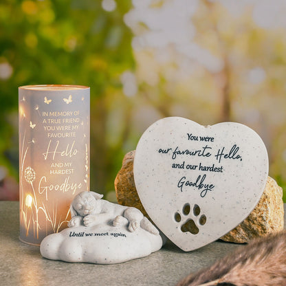 Memorial items including a candle, heart-shaped plaque, and figurine with text and paw print.