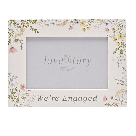 Floral photo frame with 'love story' and 'We're Engaged' text on a white background