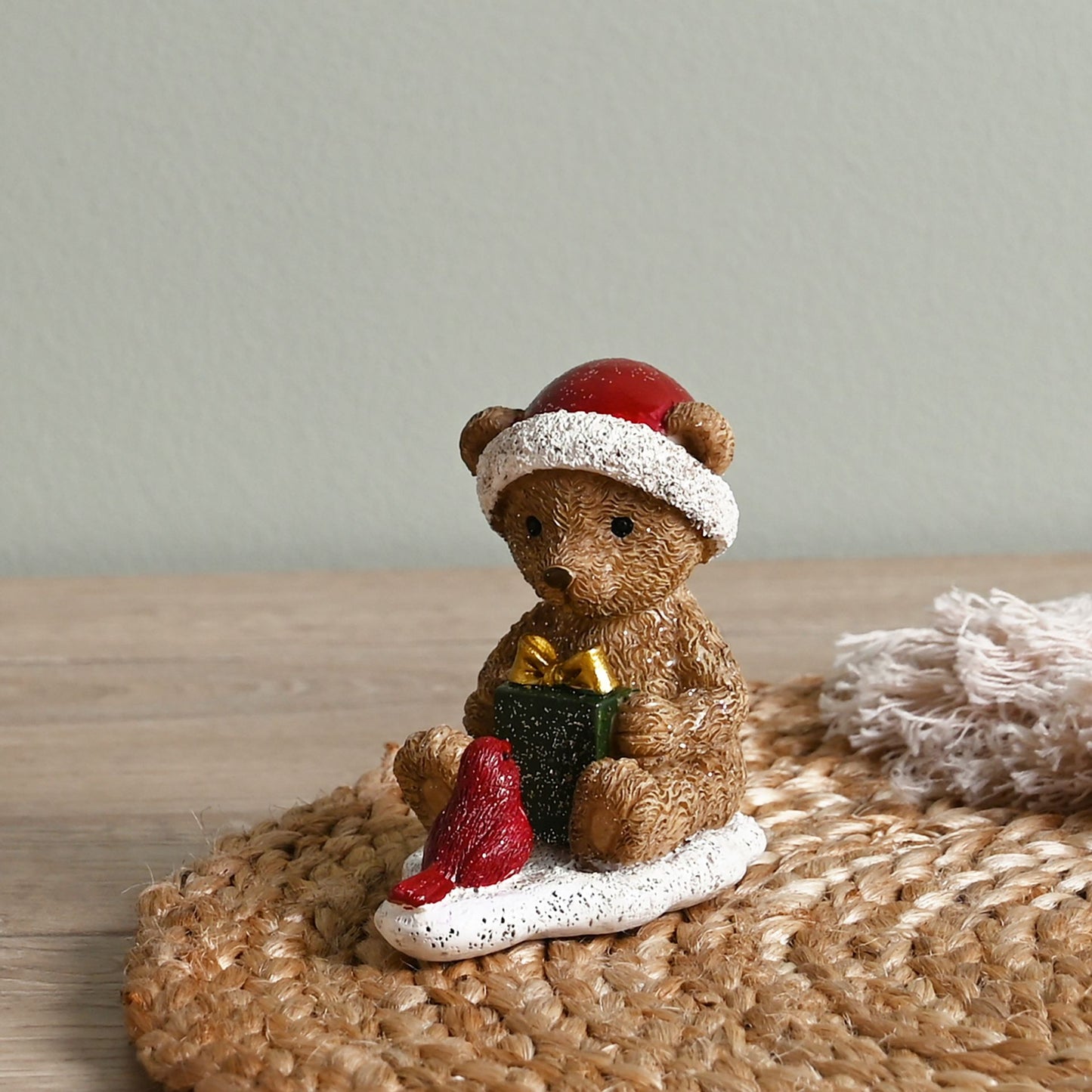 Christmas-themed figurine of a bear and bird with a Santa hat on a white background