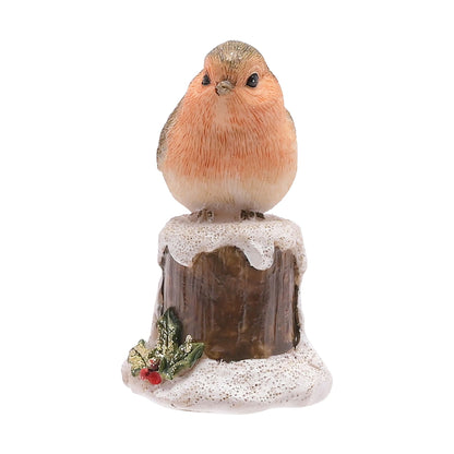 Robin on a tree stump covered in snow