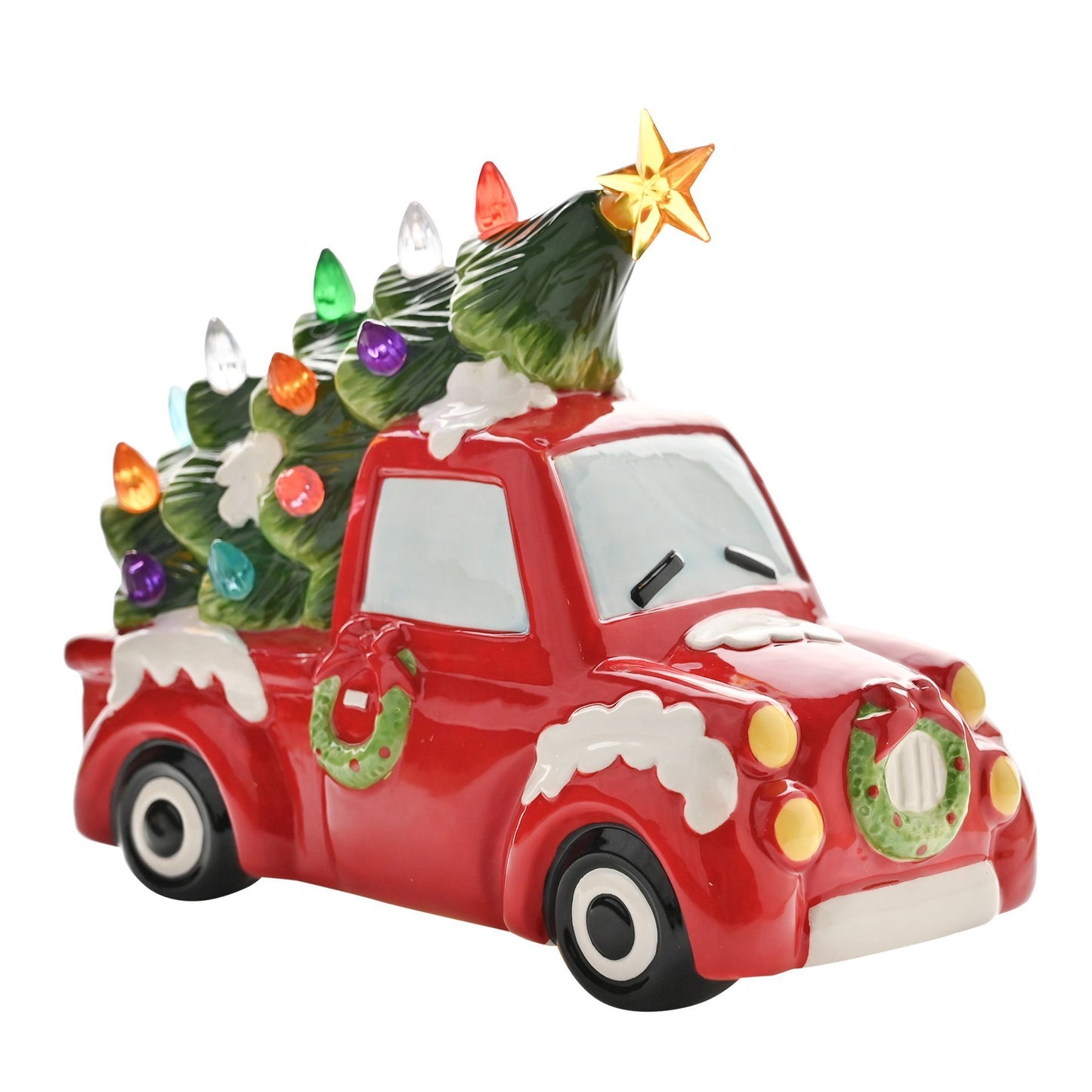 Decorative red truck with a Christmas tree on top against a white background