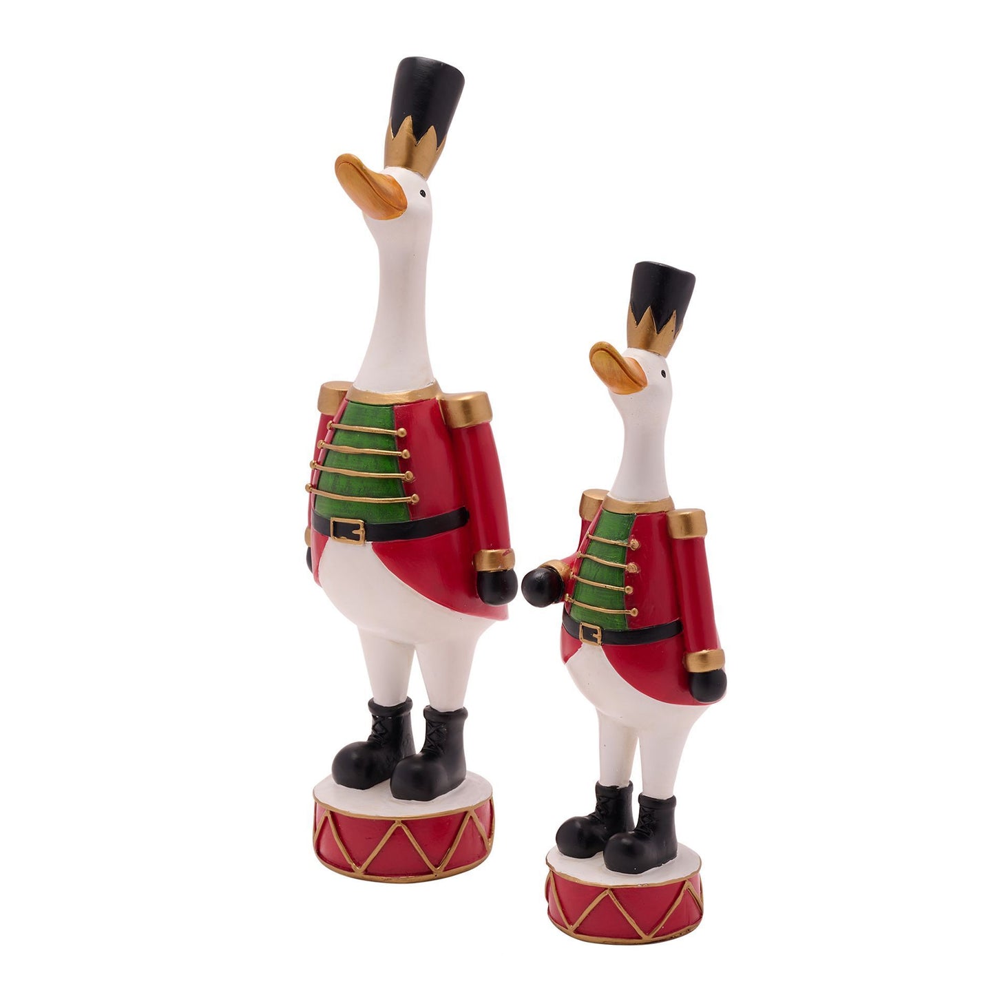 Two goose figurines in military uniforms on drums against a white background