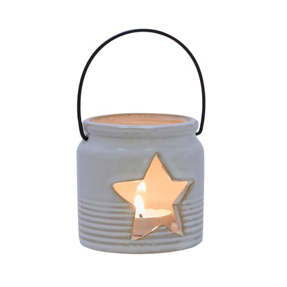 Ceramic lantern with star cutout and lit candle on a white background