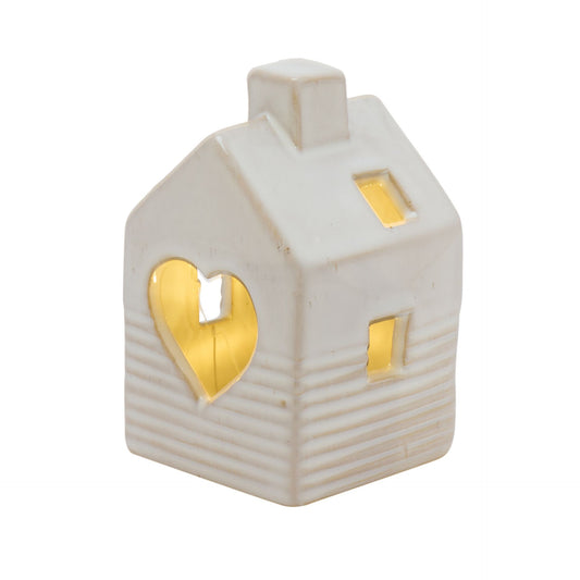 White ceramic house-shaped lantern with heart and window cutouts on a white background