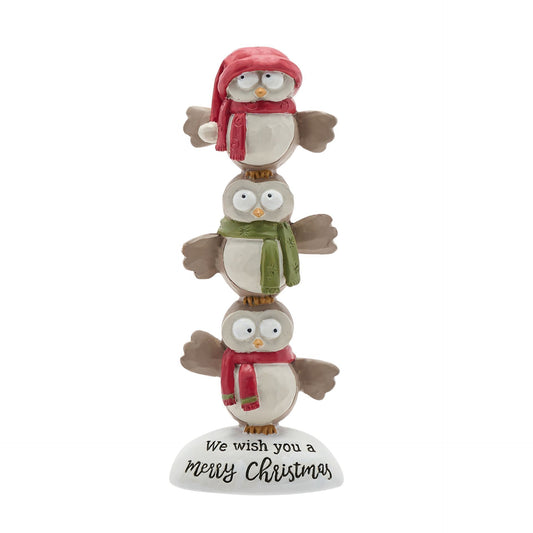 Stack of three Christmas-themed owl figurines with scarves and a hat on a white background.