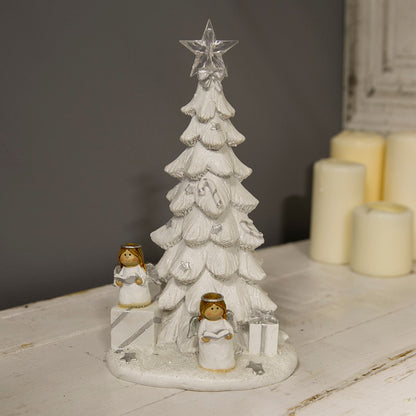 Decorative Christmas tree with star on top, two angel figures, and presents on a white surface.